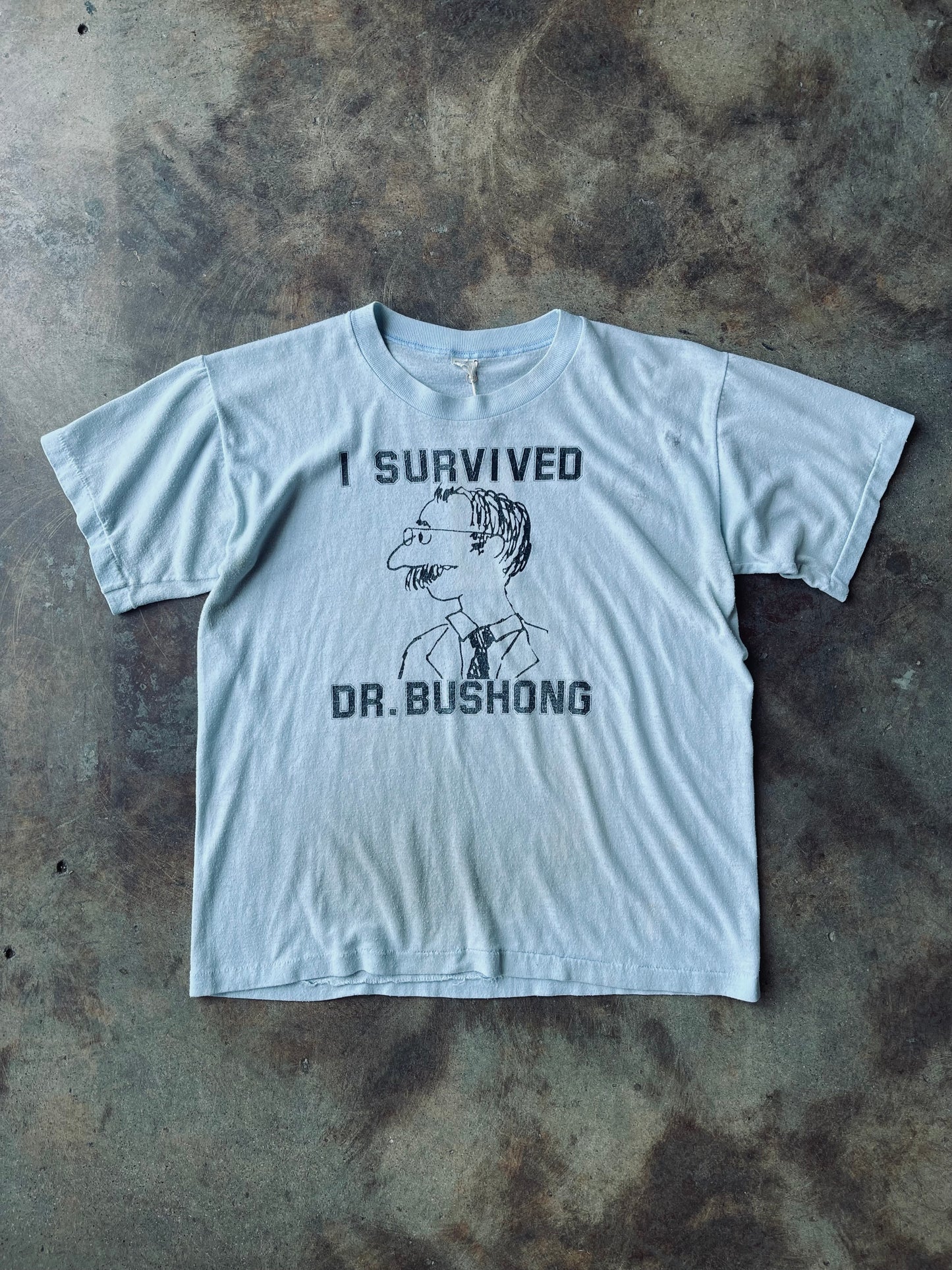 1980’s “I Survived Dr. Bushong” Graphic Tee | Large